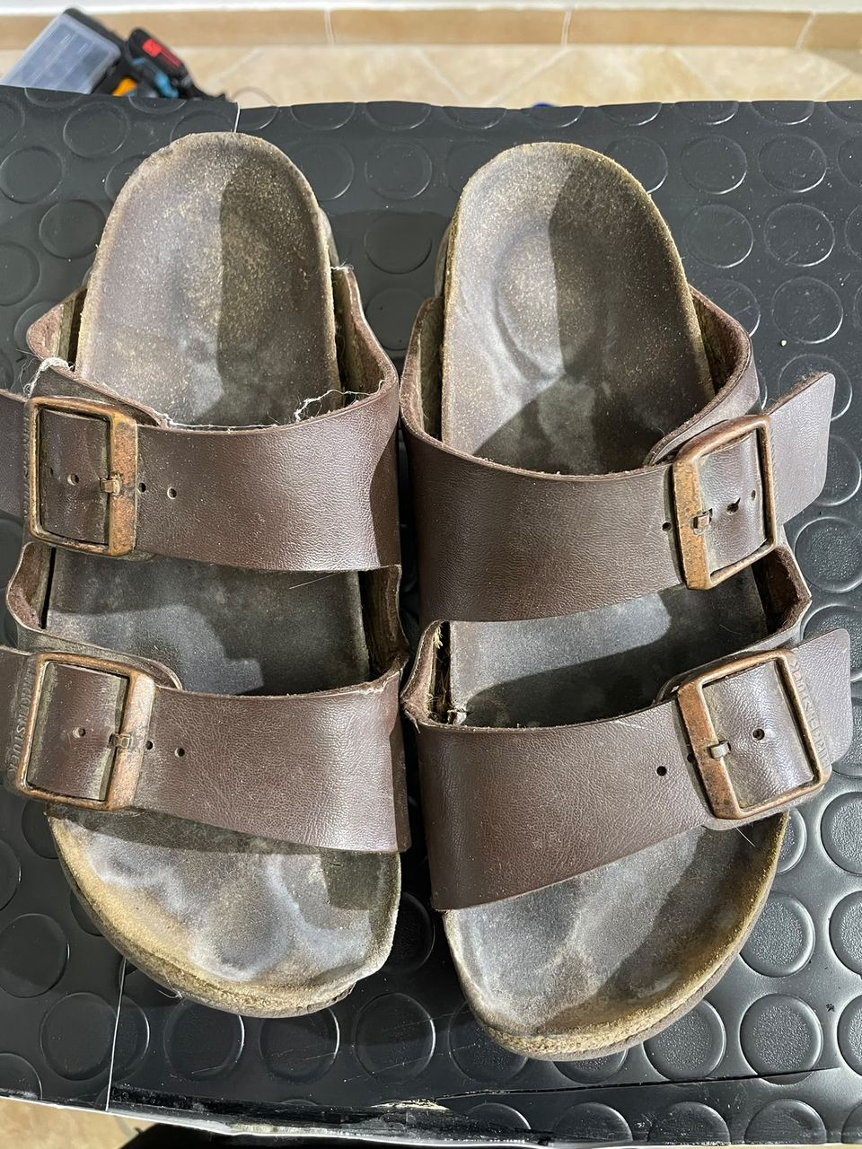Birkenstock viste dall'alto con il plantare consumato, prima del restauro