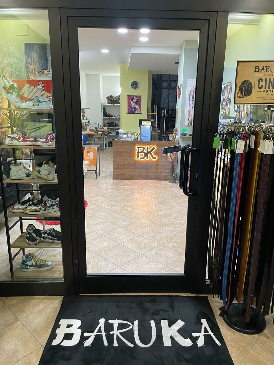 L'ingresso del negozio Calzolaio Baruka, con lo zerbino e l'insegna BK