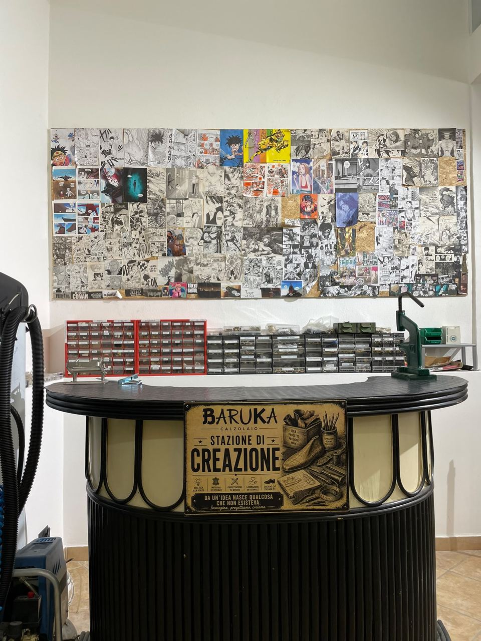 La stazione di creazione di Calzolaio Baruka, con la minuteria, la pressa e il collage di tavole manga