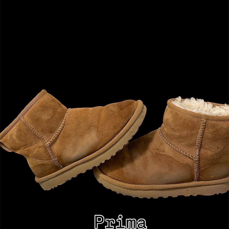 Un paio di UGG in camoscio sporche e macchiate, prima del lavaggio, vista di tre quarti