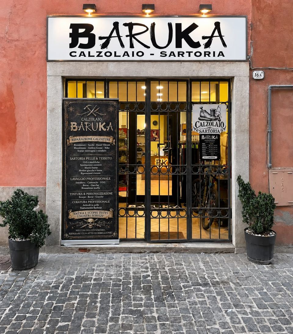La vetrina di Calzolaio Baruka a Mondovì, con l'insegna e il cartello dei servizi